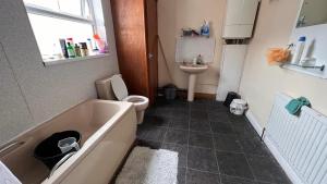 a bathroom with a tub and a toilet and a sink at 55 Holgate Db Room Shared Bathroom & Kitchen in Nottingham