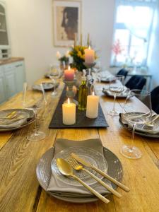 a table with plates and silverware and candles on it at Stadtnah & Naturverbunden in Luckenwalde