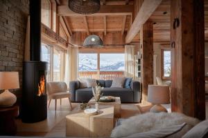 Una sala de estar con un sofá y una chimenea. en Chalet Marmot'Inn - OVO Network, en Notre-Dame-de-Bellecombe