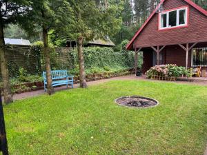 a yard with a blue bench and a house at Kaszubski sen in Smołdzino