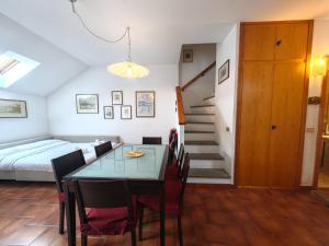 a bedroom with a dining room table and a bed at Hostdomus - Le Morette in Cesana Torinese