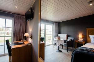 a hotel room with a bed and a desk and a table at B&B De Bergvallei in Oedelem