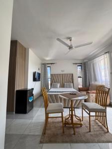 a living room with a bed and a table and chairs at Kheyre Nyali Ocean View Studio Apartments in Mombasa