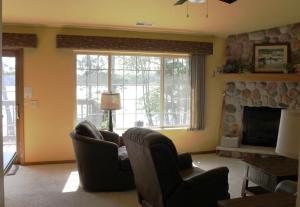 a living room with two chairs and a fireplace at Duck Lake 2 bedroom condo at Wild Eagle Lodge, #206 in Eagle River +19 photos