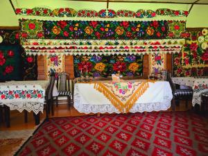 a dining room with a table and chairs with a rug at Pensiunea Rustic Oncesti in Onceşti