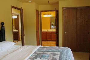 a bedroom with a bed and a bathroom with a sink at Duck Lake 2 bedroom condo at Wild Eagle Lodge, #206 in Eagle River