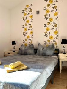 1 dormitorio con 1 cama con flores amarillas en la pared en Apartments Harmoney, en Rukavac