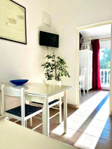 Una cocina y un comedor con una mesa y sillas blancas. en Apartments Harmoney, en Rukavac