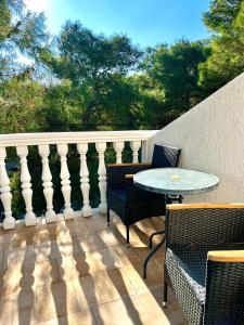 Un patio con una mesa y sillas en un balcón. en Apartments Harmoney, en Rukavac