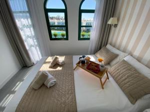 a bedroom with a bed and a table and windows at Bungalow Dunaflor Verde 4 in San Bartolomé +38 photos