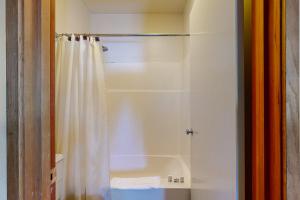 a bathroom with a shower with a white shower curtain at Meadow House 11 | Discover Sunriver in Sunriver +16 photos