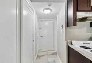 a kitchen with a hallway leading to a door at Upscale Studio in NY with Kitchen & Serene Setting in Congers +39 photos