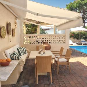 a patio with a table and chairs and a pool at Elegant Villa in Vilamoura with Private Pool in Vilamoura