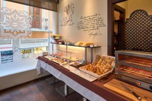 Monjas del Carmen Hotel في غرناطة: مخبز مع طاولة مع حلويات متنوعة عليه