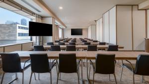 ein leerer Konferenzraum mit einem großen Tisch und Stühlen in der Unterkunft AC Hotel Milano by Marriott in Mailand