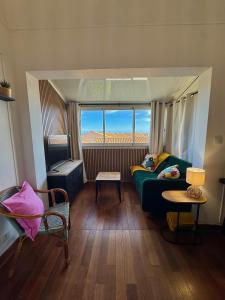 a living room with a green couch and a window at Mon Rooftop à la Plage in Frontignan +32 photos