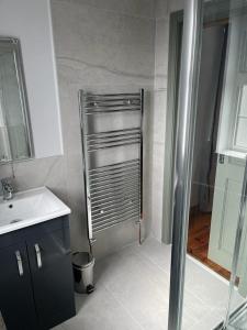 a small bathroom with a shower and a sink at Hill House, panoramic Burren views, ideal location in Kilfenora