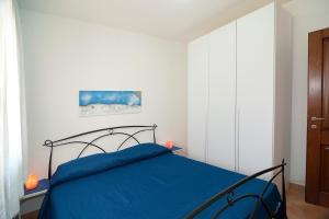 a bedroom with a bed with a blue blanket at Appartamento vicino alla spiaggia -G- in Tanaunella