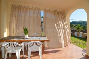 a dining room with a table and chairs and a window at Appartamento vicino alla spiaggia -G- in Tanaunella