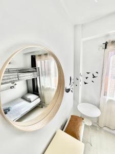 a round mirror in a white room with a chair at Casa Canaria shared house in El Médano +4 photos