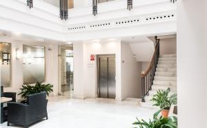 a lobby of a building with stairs and plants at Monjas del Carmen Hotel in Granada