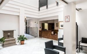 a living room with a fireplace and chairs at Monjas del Carmen Hotel in Granada