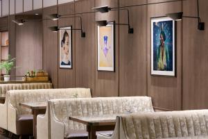 a waiting room with couches and paintings on the walls at AC Hotel Milano by Marriott in Milan