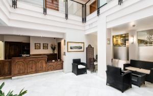 a salon with a waiting area with black chairs at Monjas del Carmen Hotel in Granada
