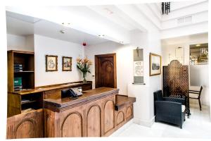 a lobby with a reception desk and a chair at Monjas del Carmen Hotel in Granada