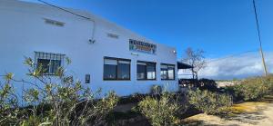 een wit gebouw met een bord aan de zijkant bij Casa Bassa de La Marquesa in Deltebre