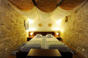 a room with two beds in a stone wall at Casa.Peiso in Mörbisch am See