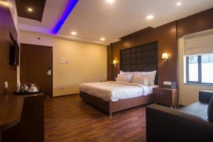 a hotel room with a bed and a television at Hotel Sawood International in Kolkata