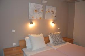 a bedroom with a bed with white sheets and pillows at Akis Apartments in Paleokastritsa