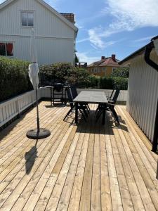 a patio with a table and chairs on a wooden deck at Newly renovated, near town center in Grebbestad