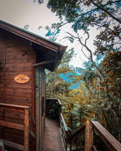 a wooden cabin with a sign on the side of it at Chalé Morada dos Tucanos in Santo Amaro da Imperatriz