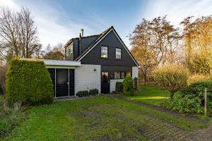 ein Schwarz-Weiß-Haus mit Garten in der Unterkunft Groenendijk Verhuur Vakantiehuis Jonas Burgh-Haamstede in Burgh Haamstede