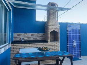 une table avec un bol de fruits sur une terrasse dans l'établissement Unamar, conforto em frente a praia!, à Cabo Frio
