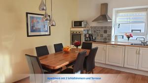 a kitchen and dining room with a wooden table and chairs at Urlaubsapartment am Silbersee in Villach