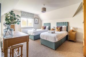 een slaapkamer met twee bedden en een bureau erin bij Church Cottage Stiffkey in Stiffkey