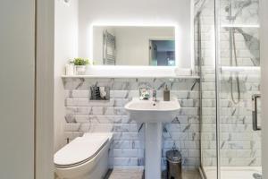 een witte badkamer met een toilet en een wastafel bij Church Cottage Stiffkey in Stiffkey +41 foto's