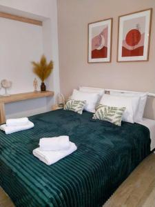 Un dormitorio con una cama verde con toallas. en Mea Casa Comfort Home, en Pitsidia 27 fotos más