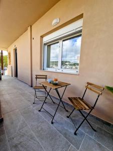 un patio con 2 sillas, una mesa y una ventana en Mea Casa Comfort Home, en Pitsidia