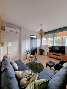 Una sala de estar con un sofá azul y un televisor en Mea Casa Comfort Home, en Pitsidia