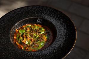 a bowl of food on a black plate at Il Grottino Relais & Spa in Gualdo Cattaneo