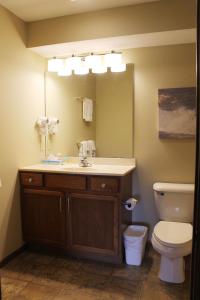 a bathroom with a sink and a toilet and a mirror at 2 Bedroom Condo at Wild Eagle Lodge, #136 in Eagle River