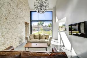 Una sala de estar con un sofá y una lámpara de araña. en Incroyable villa à Amponville avec piscine privée., en Amponville
