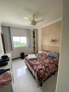 Un dormitorio con una cama y un ventilador de techo. en Residencial Candeias, en Vitória da Conquista
