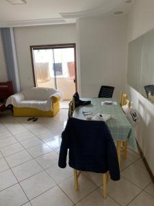 Una sala de estar con una mesa y una cama. en Residencial Candeias, en Vitória da Conquista
