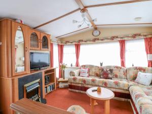 a living room with a couch and a tv at 120 Caravan in Great Yarmouth