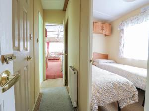 a room with two beds and a door to a bedroom at 120 Caravan in Great Yarmouth